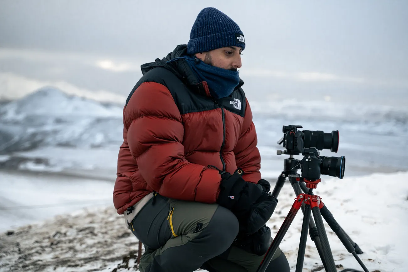 Hacomar with a tripod-mounted camera in a snowy landscape